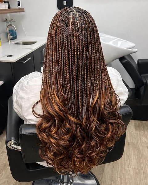 A Kim Beauty stylist finishing a client's braids